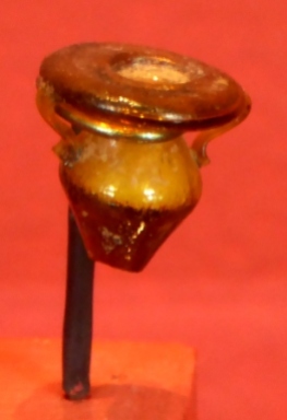 A tiny glass pot, possibly for eye ointment.